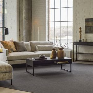 Englesson möbler i form av en soffa, soffbord och liten bokhylla i ett vardagsrum med stora fönster